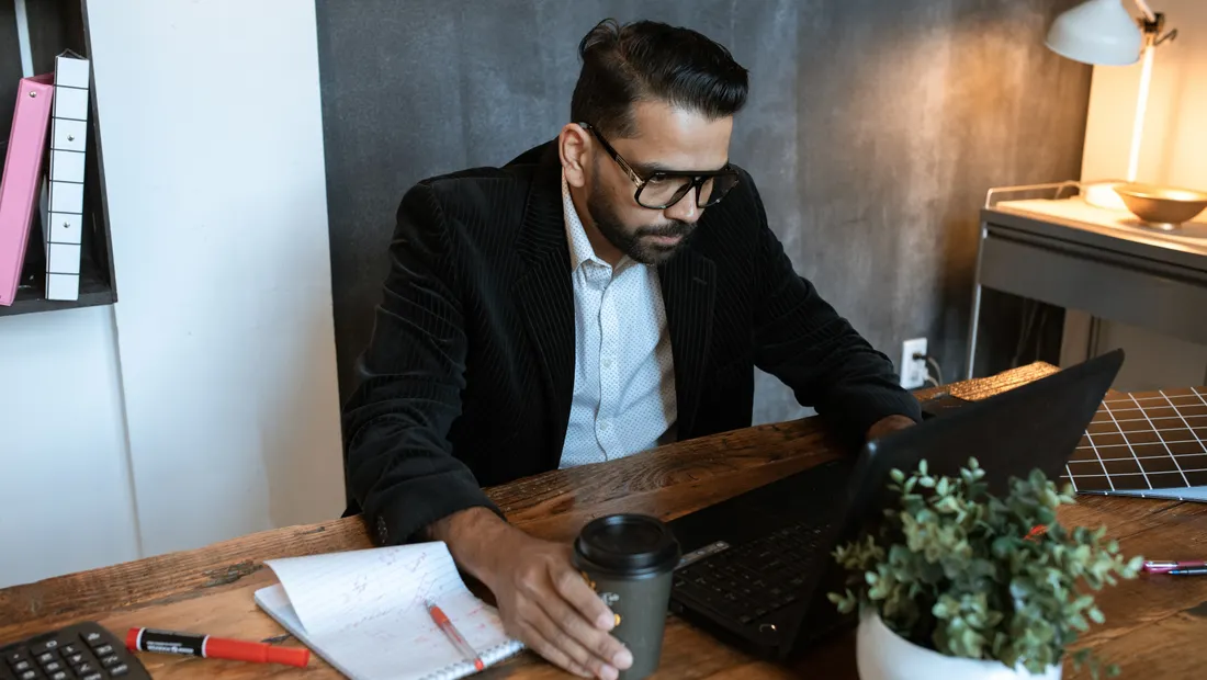 A small business owner working through a plan on his laptop