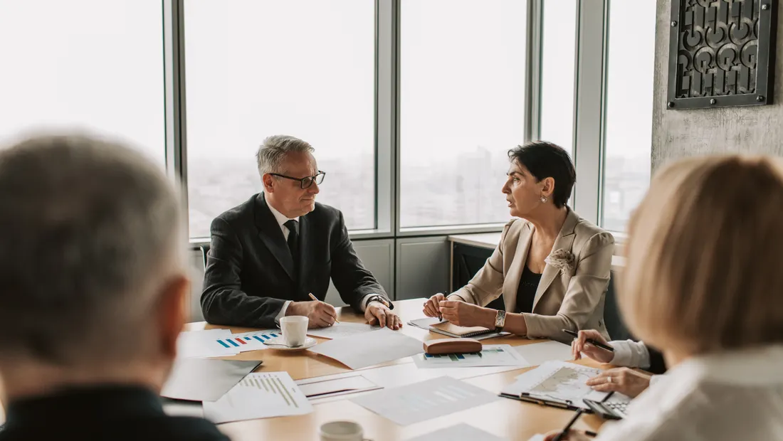 Senior leaders reviewing a plan together in a bright conference room
